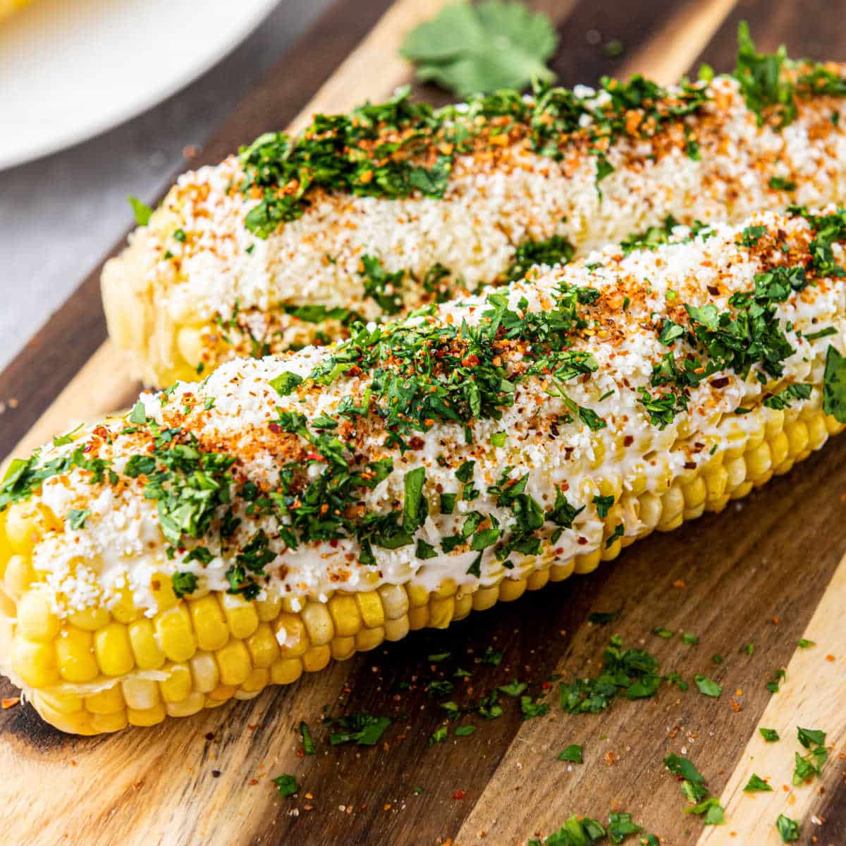 Close up of some Mexican Street Corn on a wooden board.