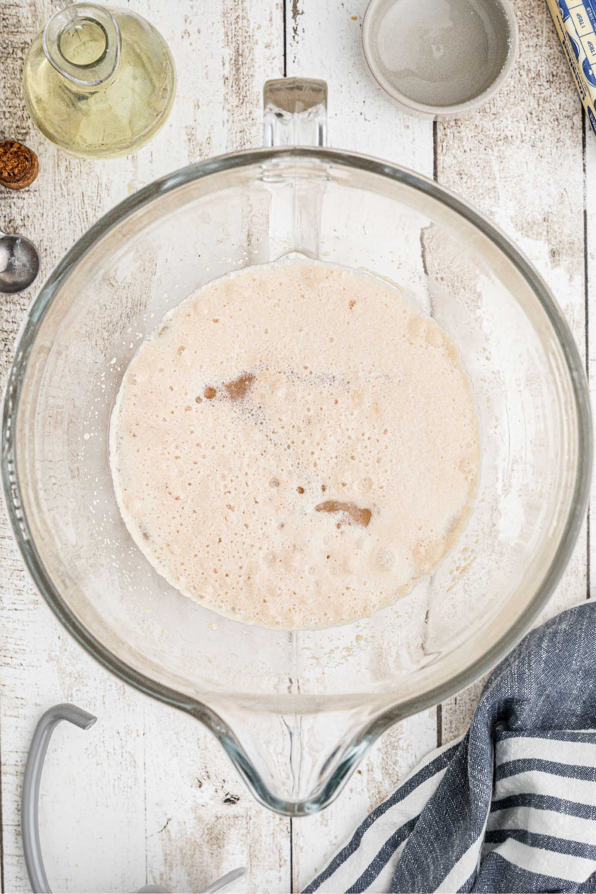 A mixer bowl with warm water and yeast added, that's starting to bloom.