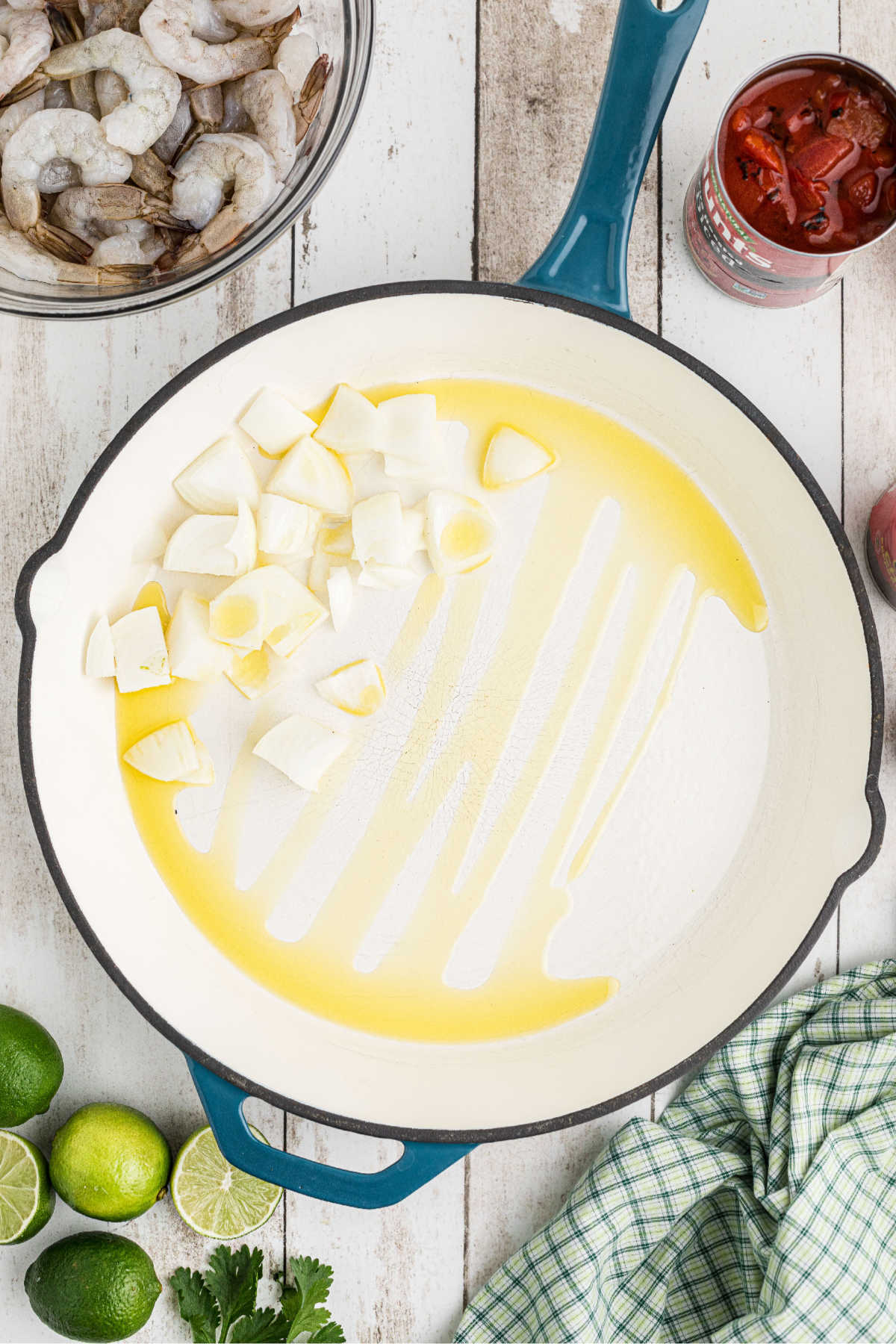 A large skillet with oil and onions.