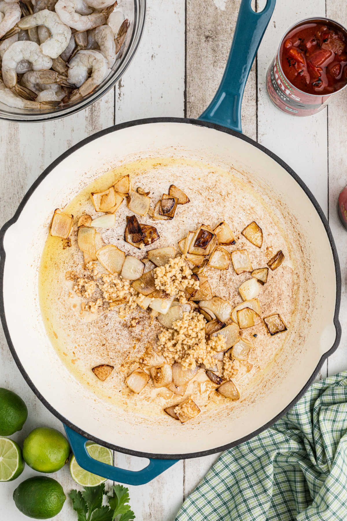 Garlic added to cooked onions in a large skillet.