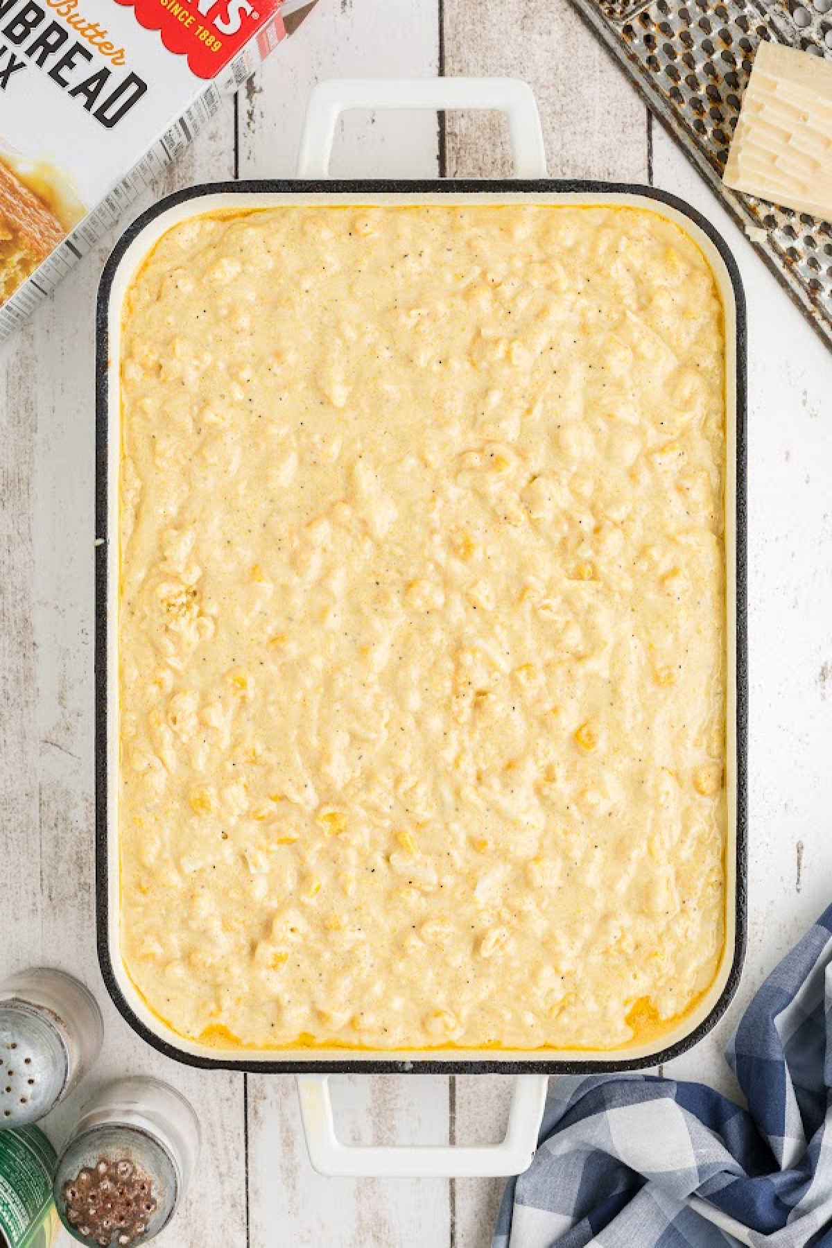 Cornbread pudding poured into a casserole dish, about to be baked.