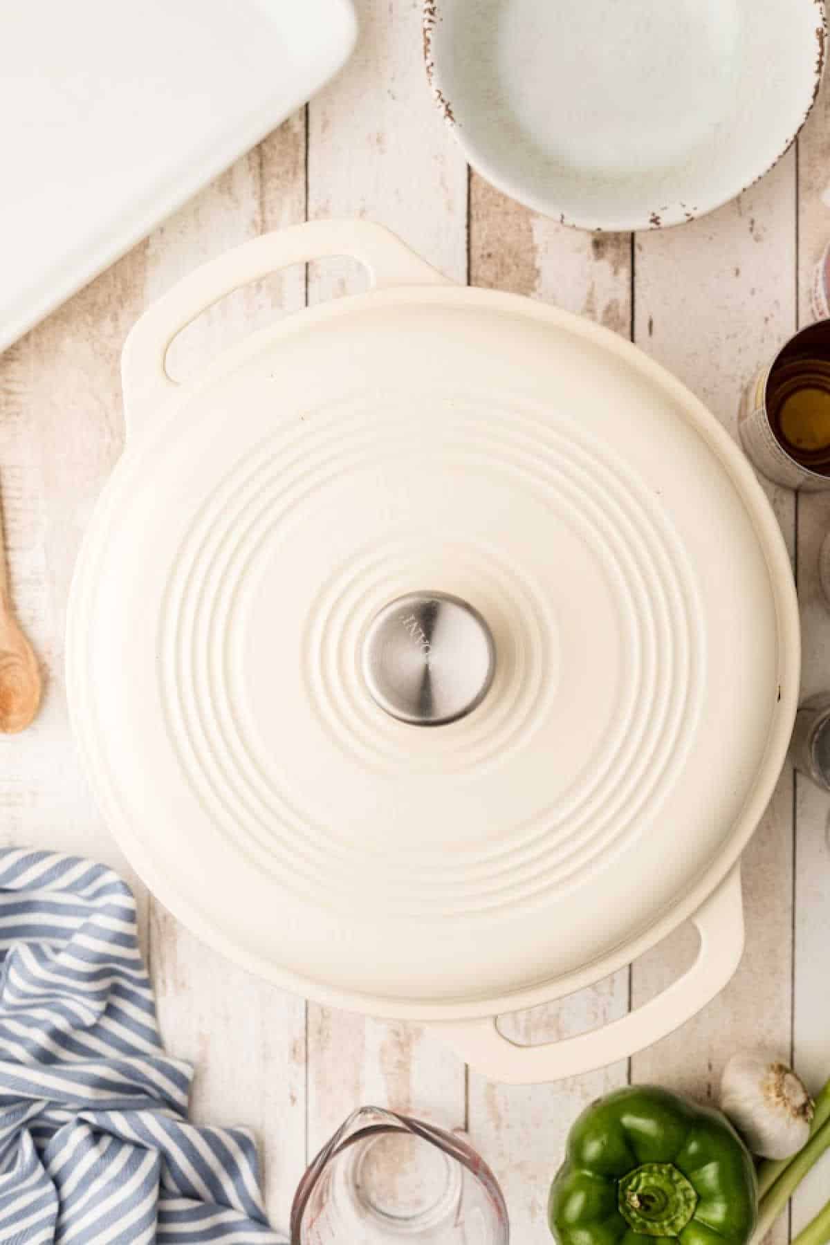 A lid closing a Dutch oven pot cooking a Pastalaya recipe.