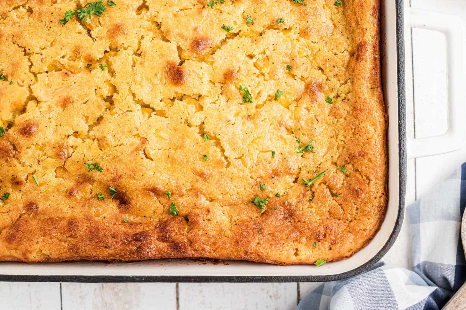 Overhead shot of a dish full of cornbread pudding, just the corner photographed.