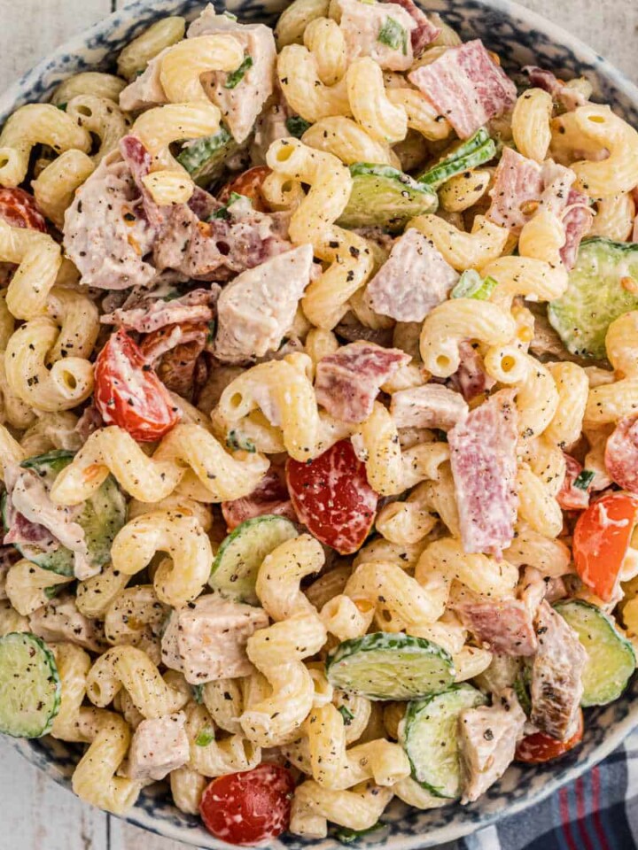 An overhead shot of a pasta salad in a blue bowl.
