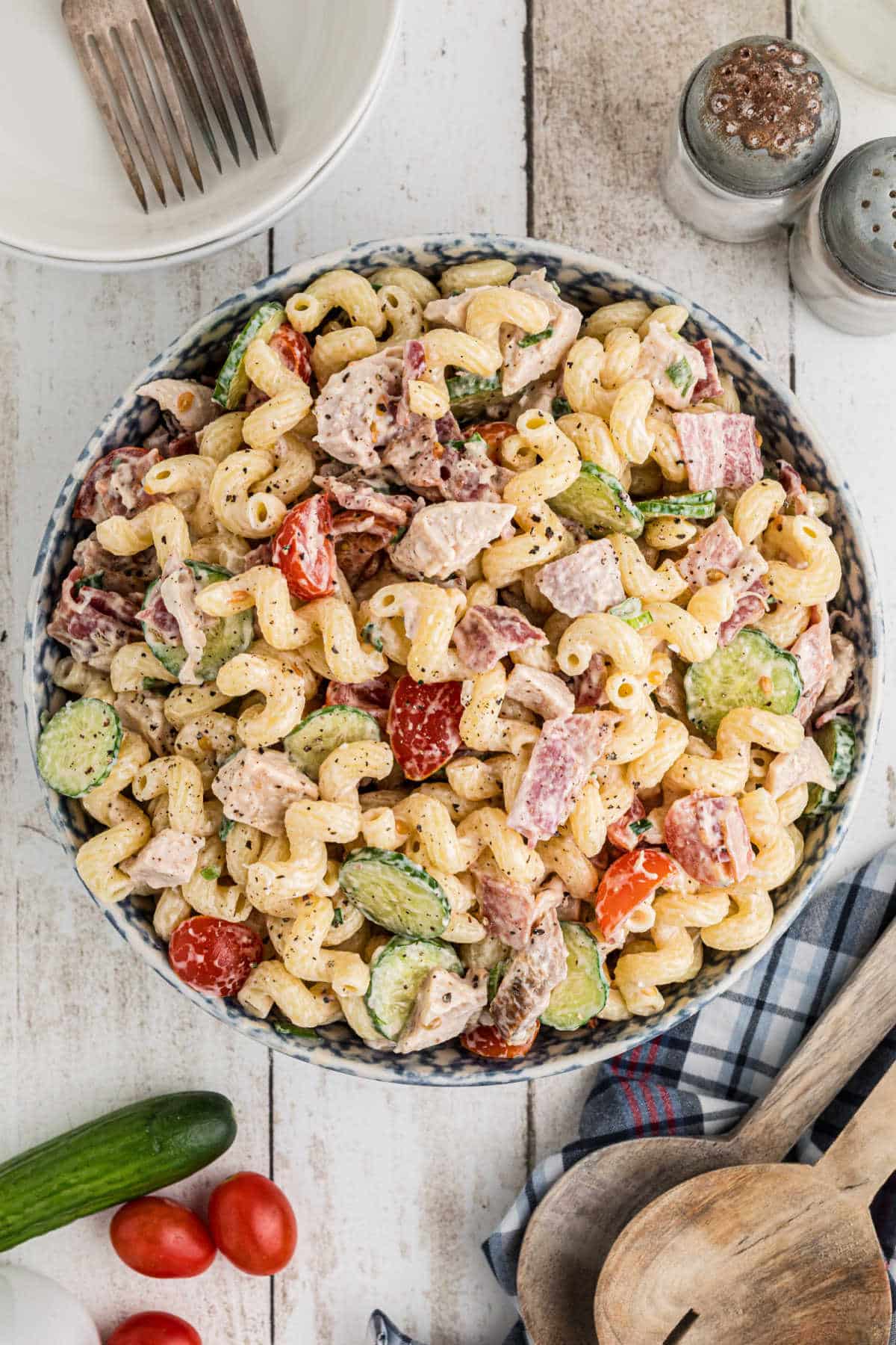 An overhead view of a bowl of chicken bacon ranch pasta salad in a blue and white bowl.
