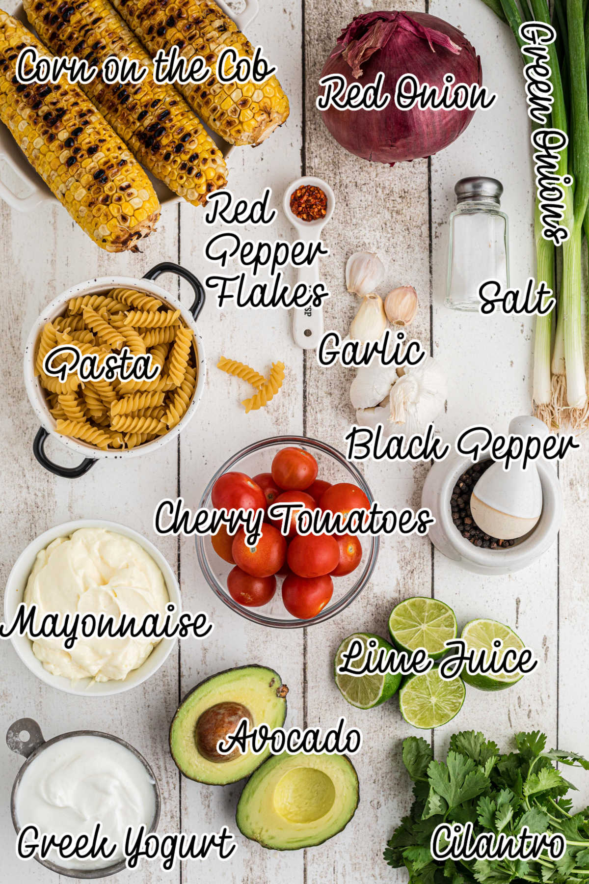 Overhead shot of ingredients laid out, showing what is needed to make a cilantro lime pasta salad recipe, with text overlay.