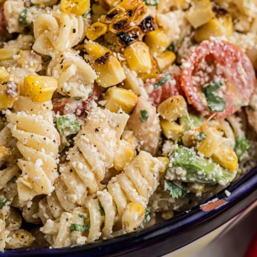 Very close up shot of a bowl of Elotes Pasta salad, cropped square.