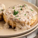 Close up of biscuits and gravy, on a plate.