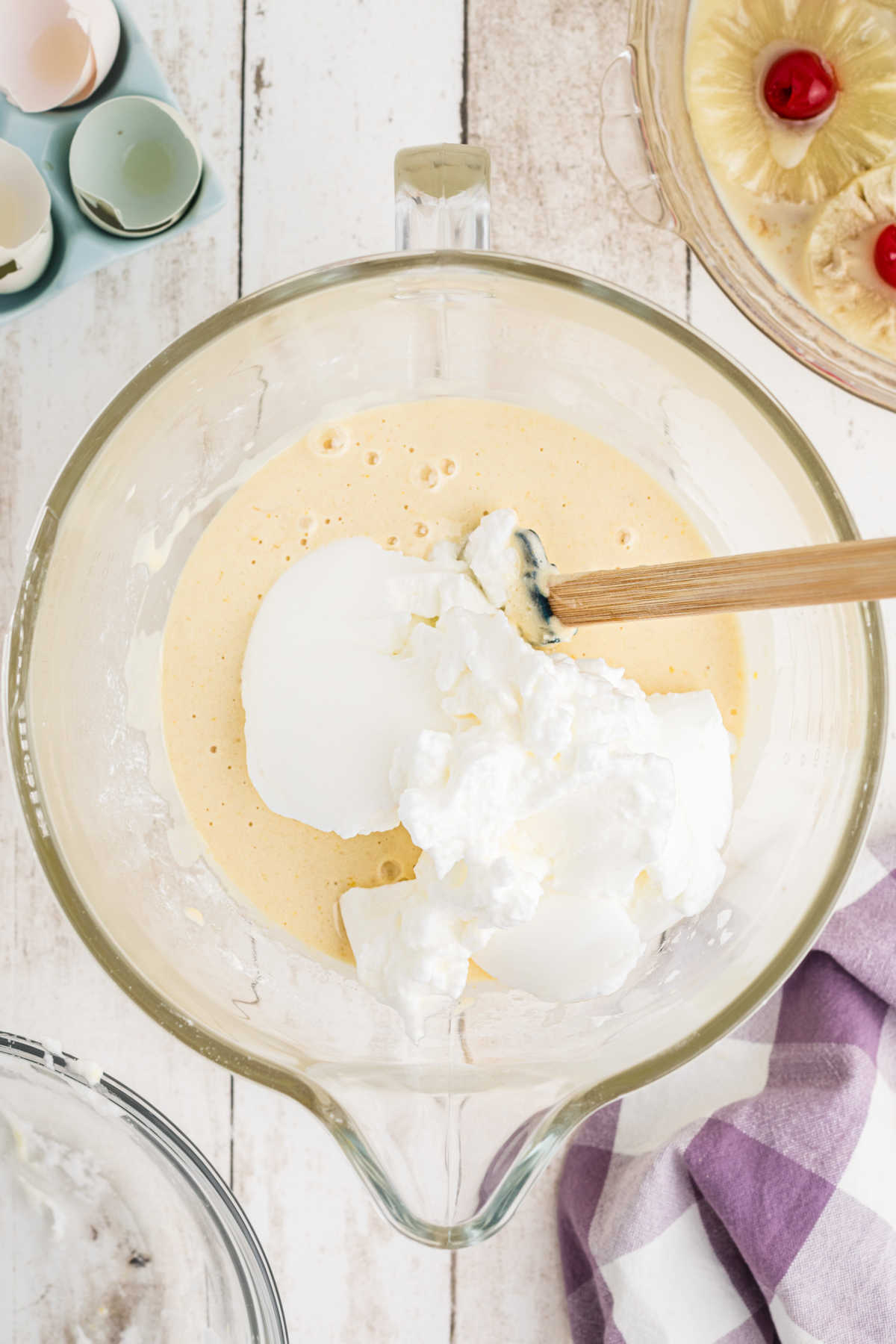 Fluffy egg whites being folded into a cake batter.