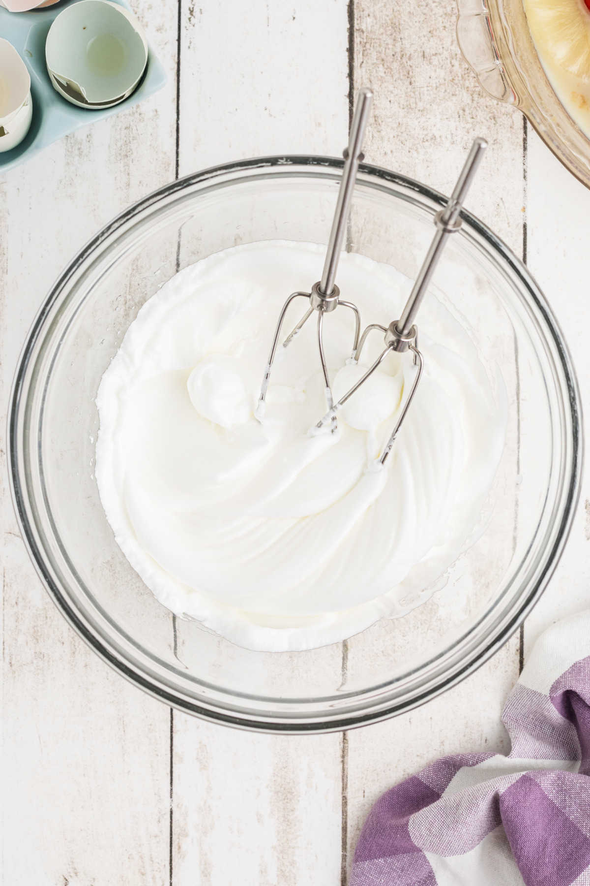 Egg whites nicely whipped up in a mixing bowl with beaters.
