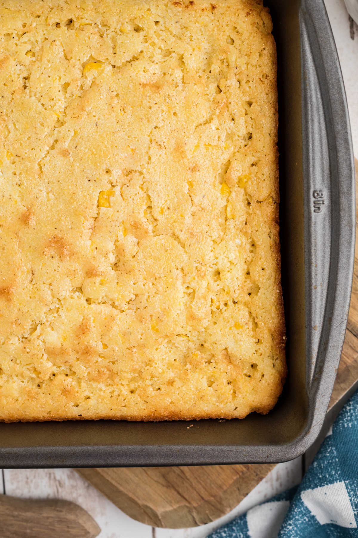OVerhead shot of the corner of a cornbread in a pan.