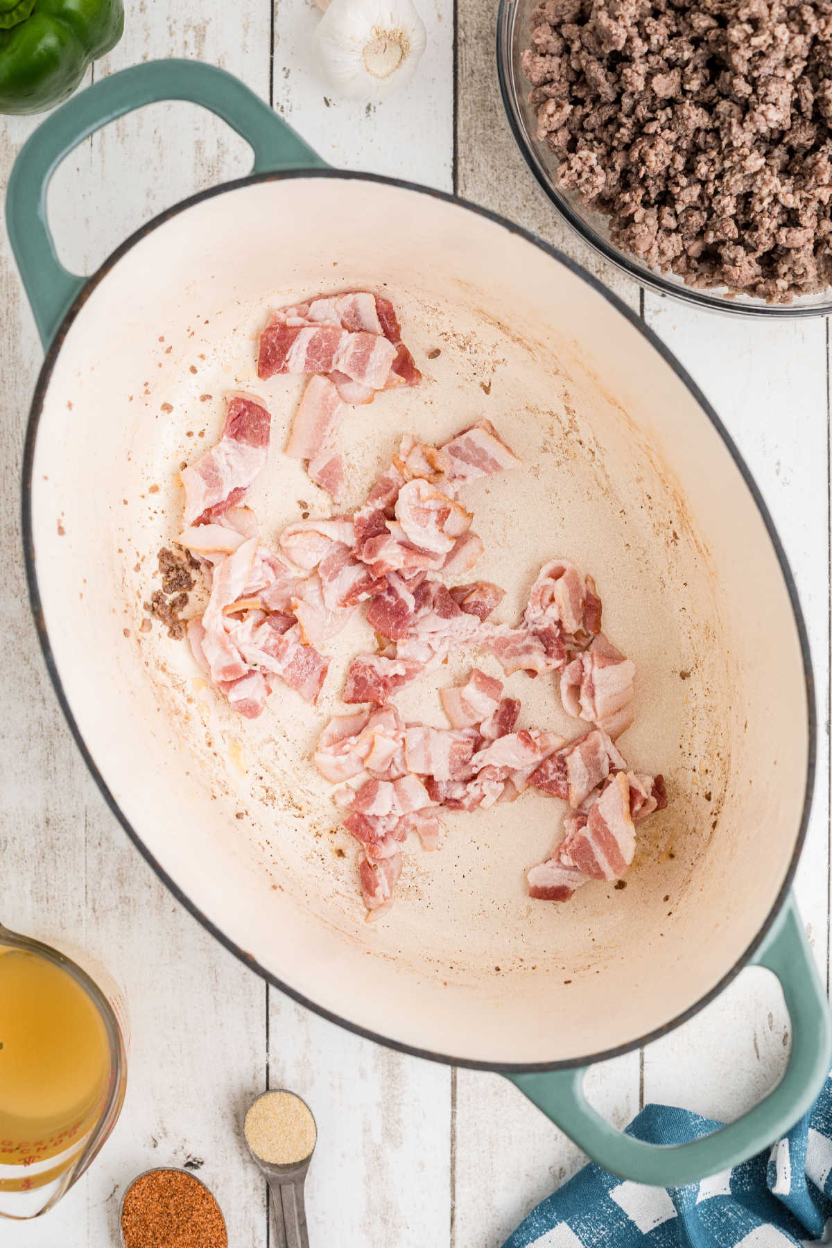 Chopped bacon being cooked in a large Dutch oven.