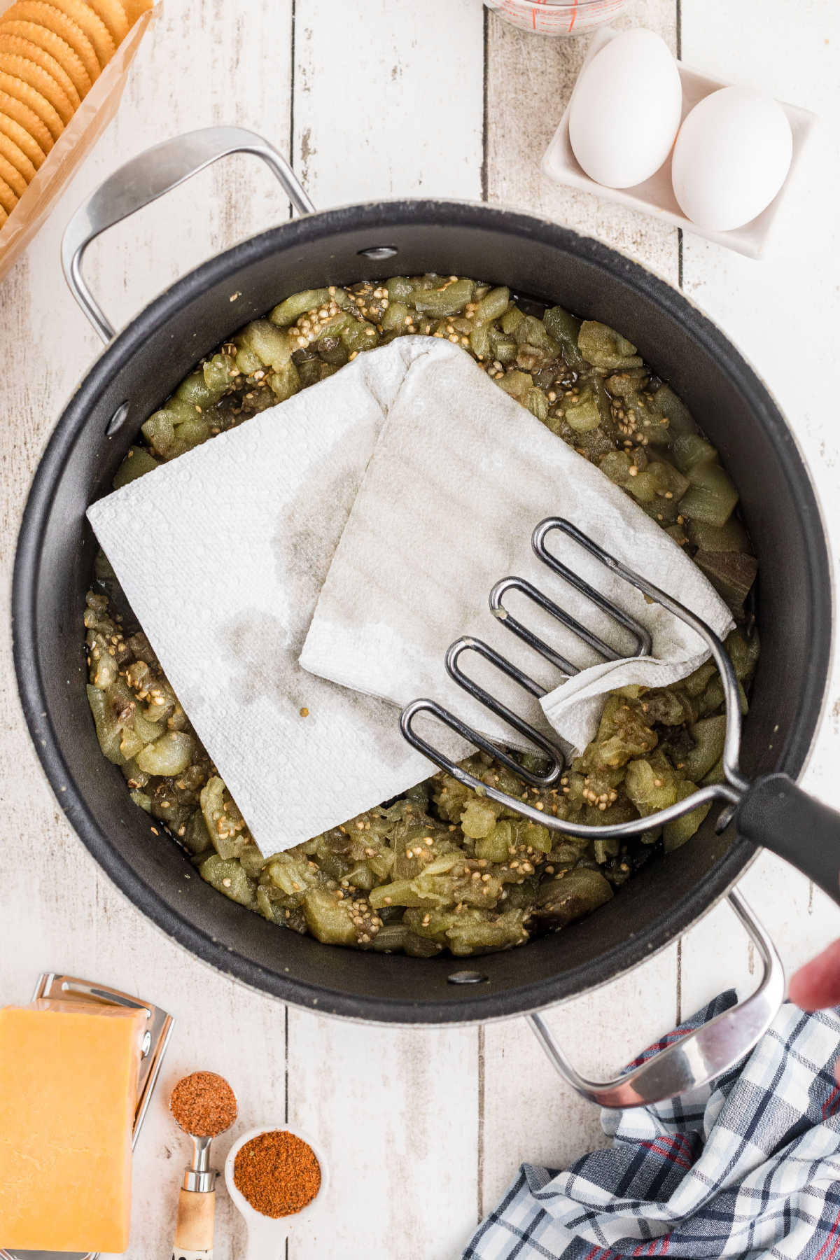 Paper towel soaking up excess fluid in mashed eggplant mixture.