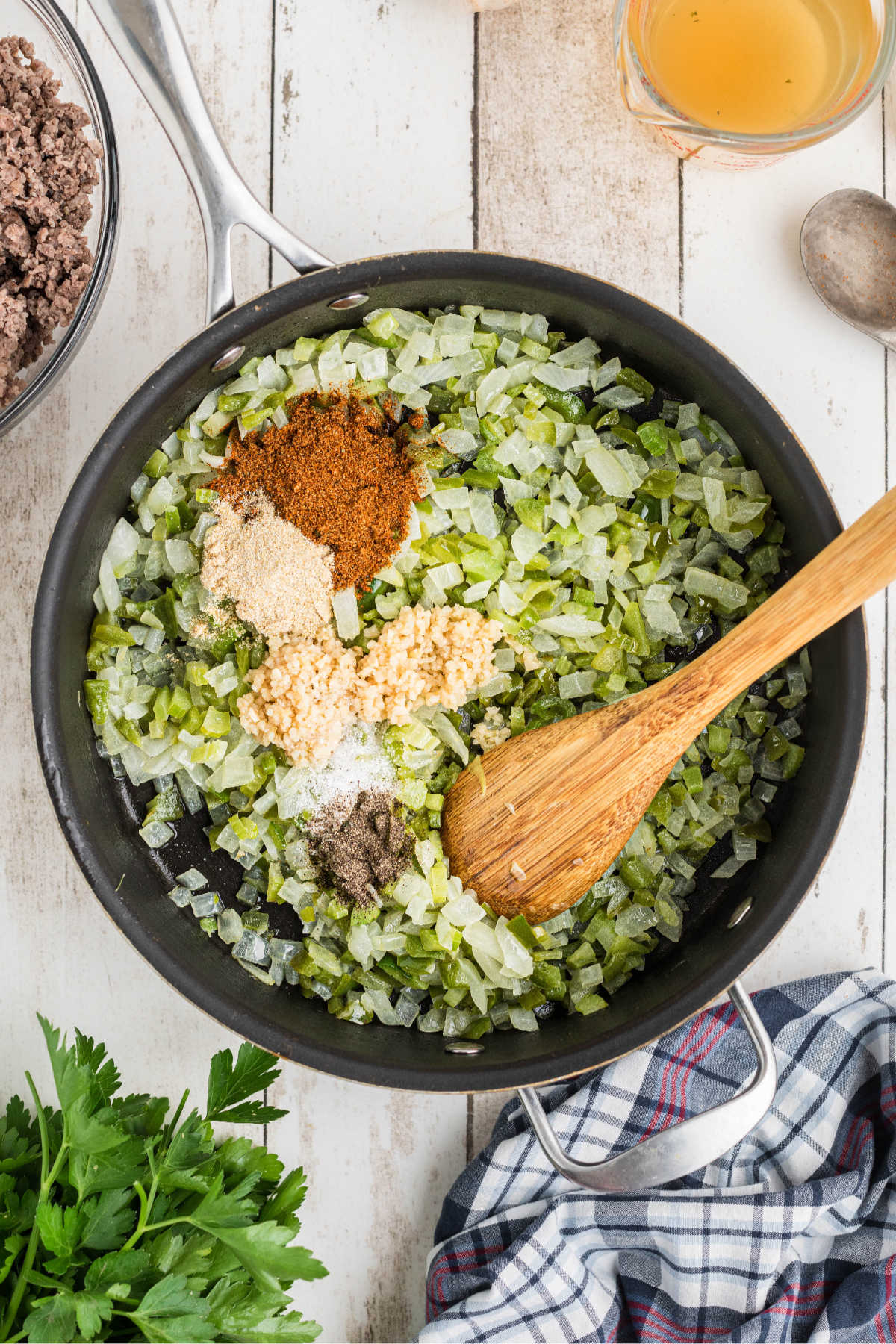Garlic and seasonings added to a pan full of veggies.