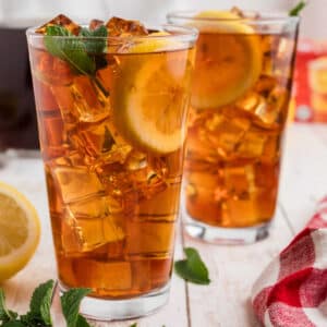 A glass of southern sweet tea with a slice of lemon and mint.