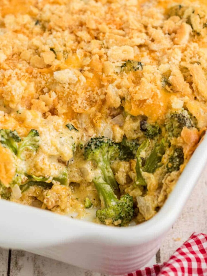 Close up of a corner of a baking dish with broccoli casserole, with a scoop missing.