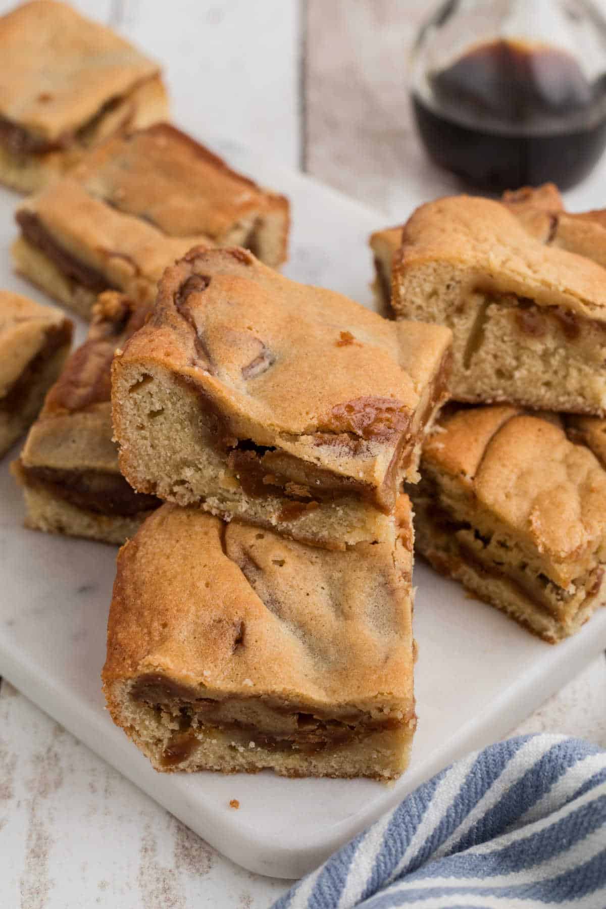 Side view of some caramel blondies, stacked on each other.