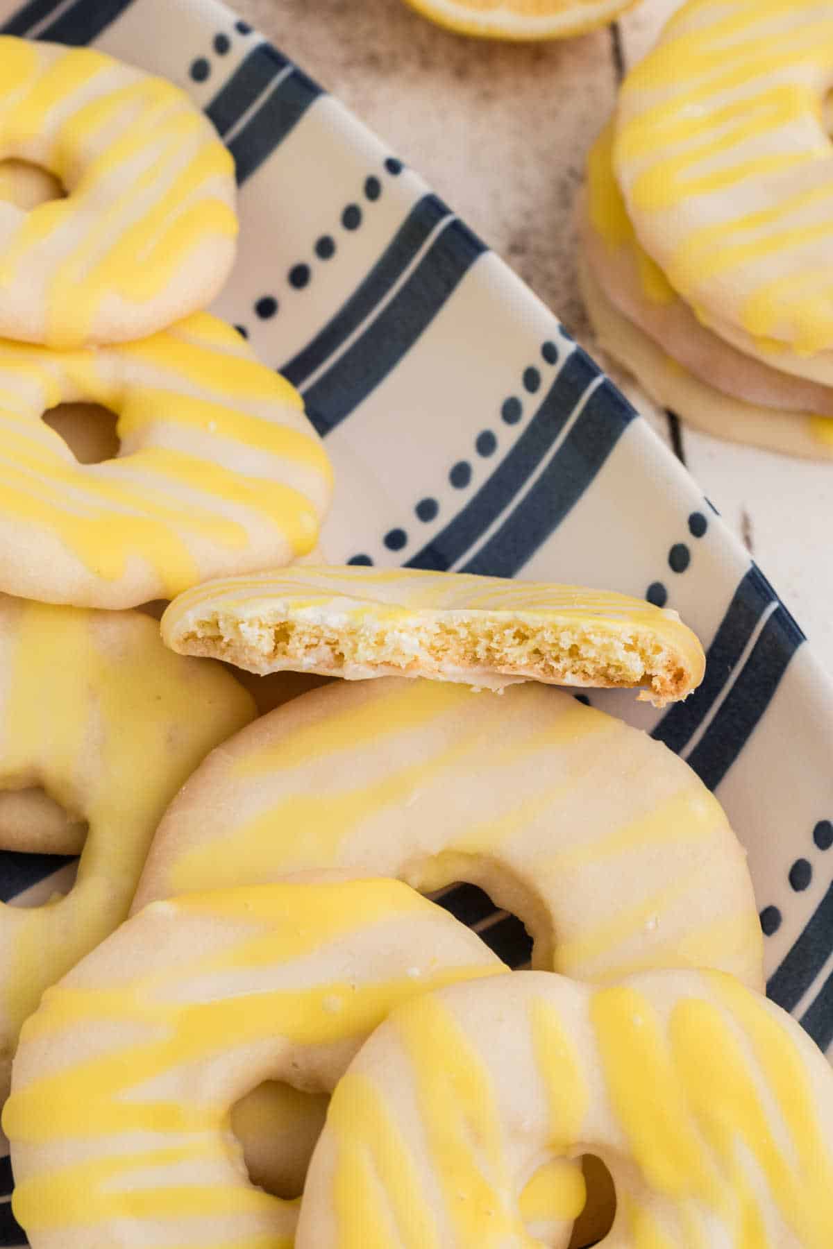 Close up of a plate of lemon jumbles, one with bites taken out.