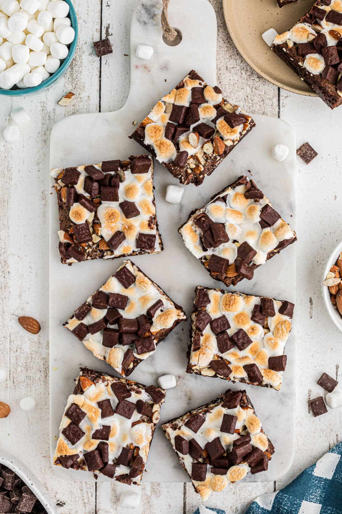 Overhead shot of some rocky road brownies cut into squares on a board.