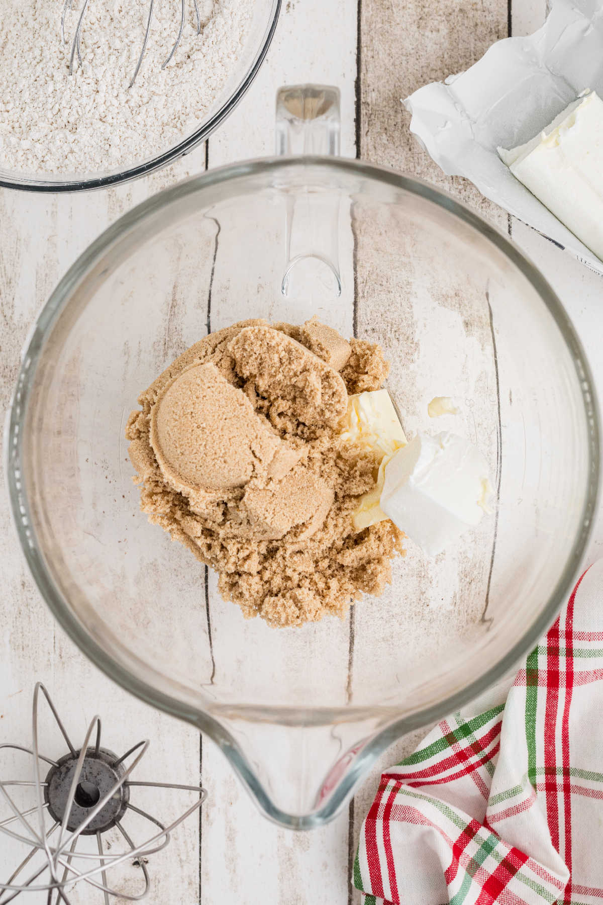 Brown sugar added to a mixing bowl with shortening and butter.