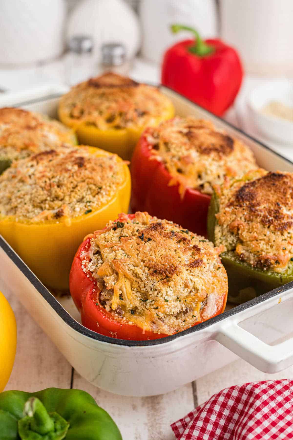 A baking dish with stuffed bell peppers, topped with breadcrumbs.