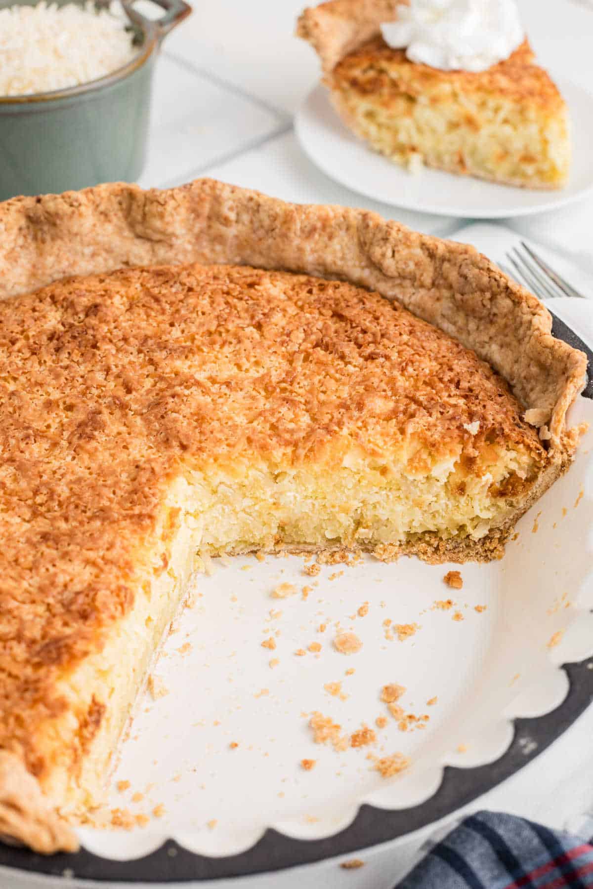 Old fashioned coconut pie with some slices removed.