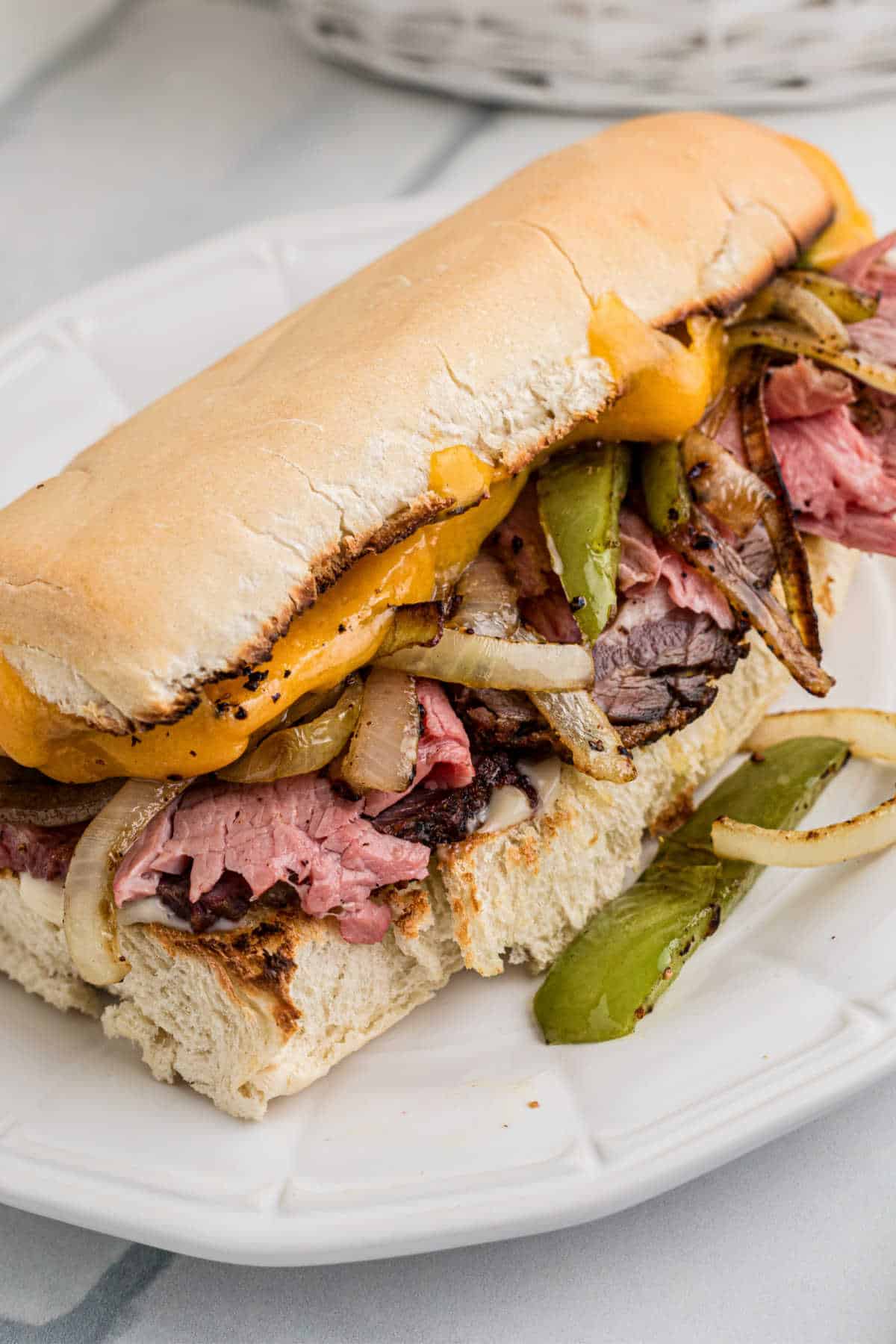 A leftover prime rib sandwich, stuffed to the brim with shaved prime rib, peppers and onions and melted cheese.