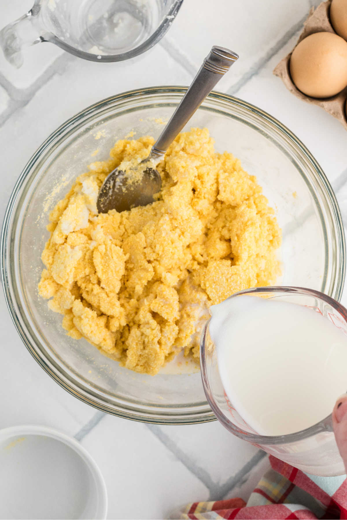 Milk being poured into spoon bread batter.