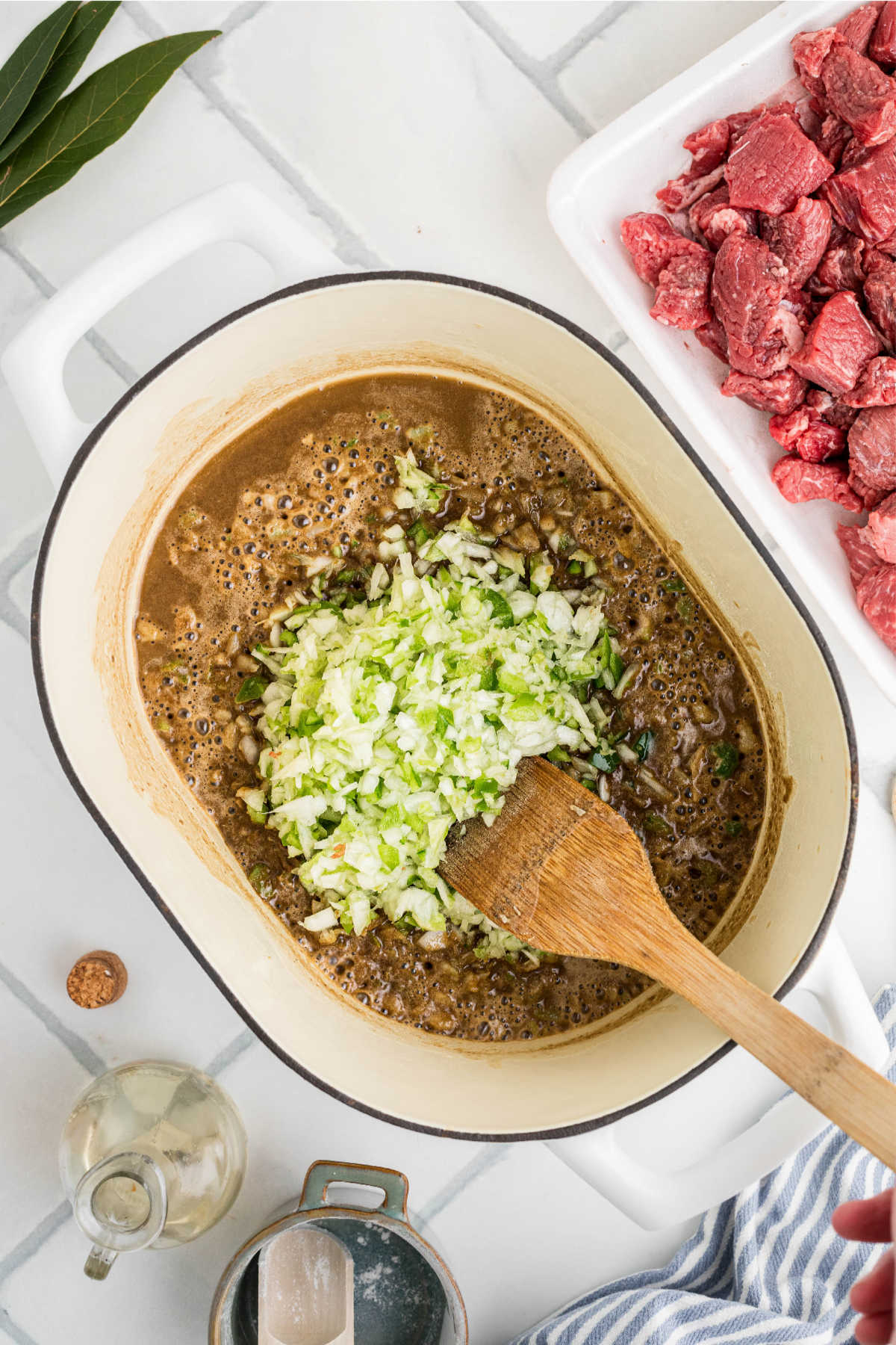 Onions and peppers added to a pot of roux.