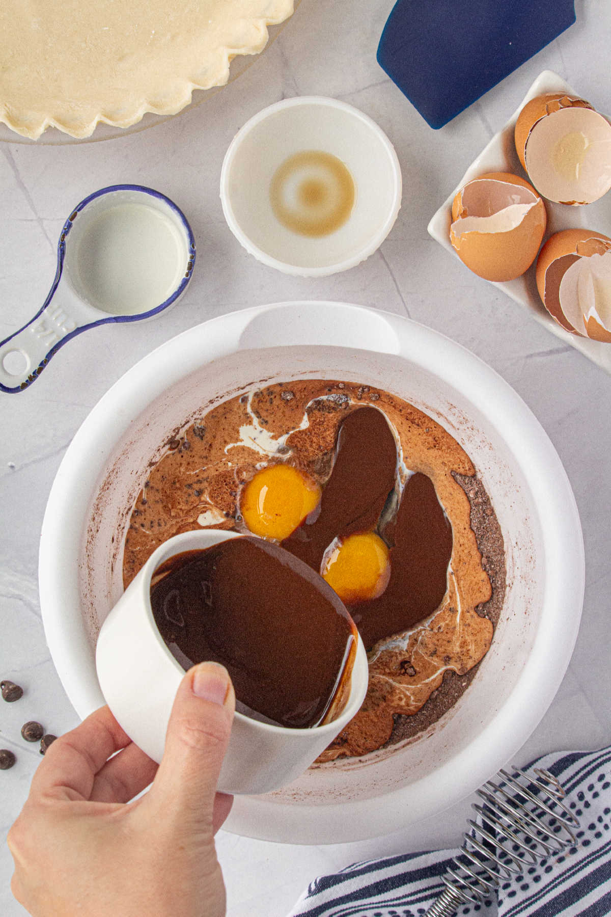 Melted chocolate being poured into a bowl of dry ingredients.