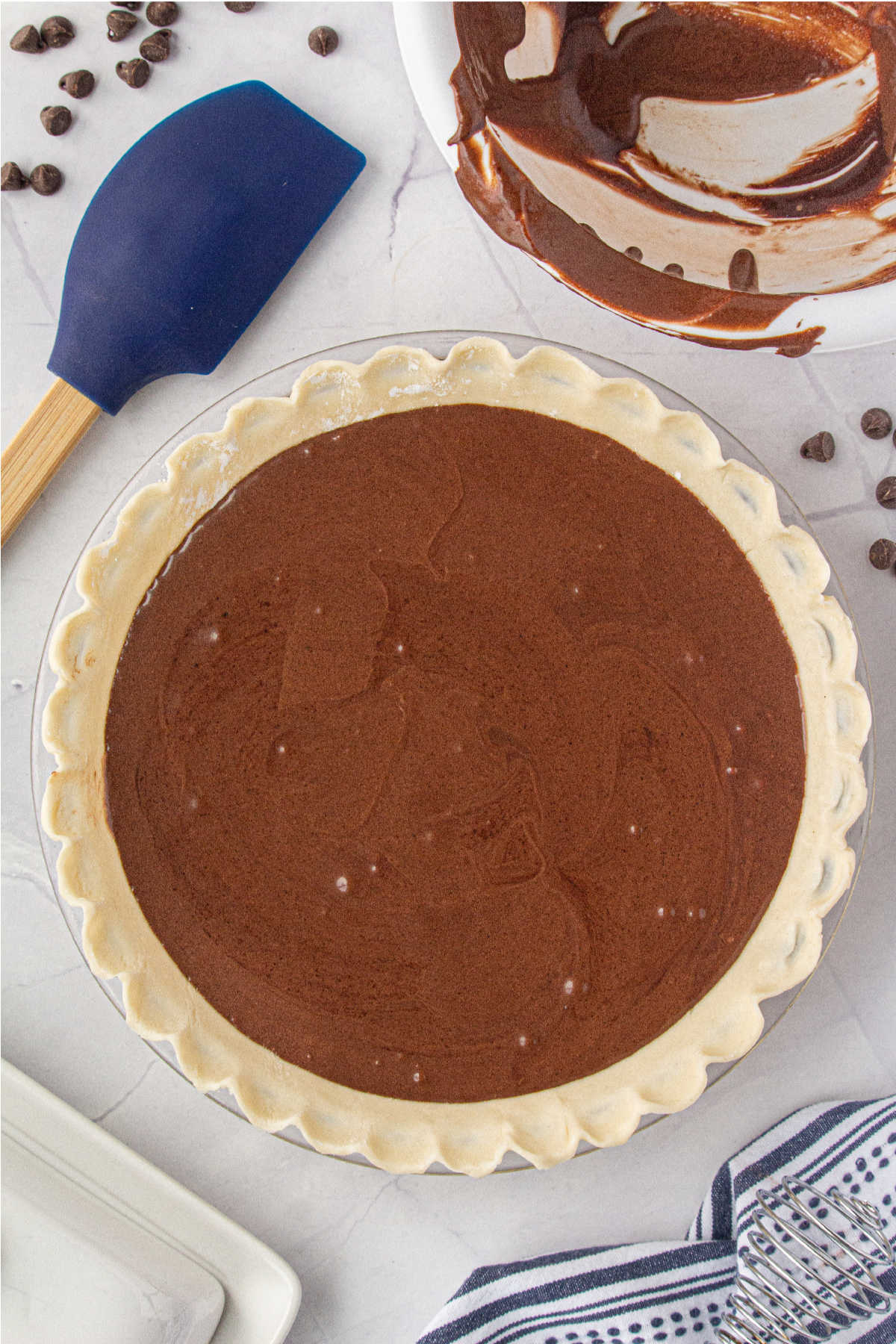 Pie filling being added to a pie crust and ready to bake.