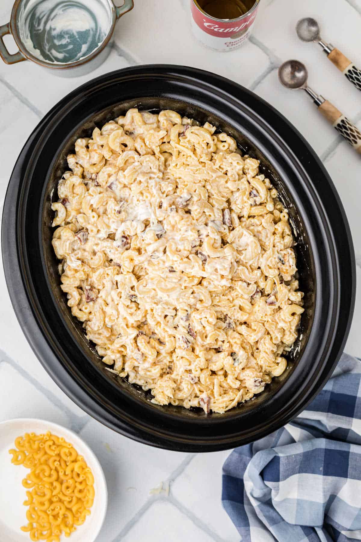 Cajun mac and cheese added to a large crock pot.