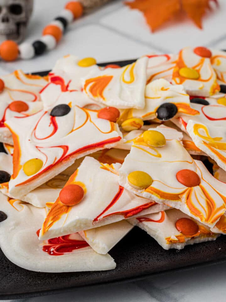 A plate with chocolate bark broken up into pieces, with fall colors.