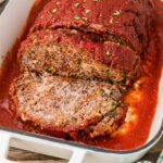Close up view of a Cajun meatloaf sliced in a baking dish.
