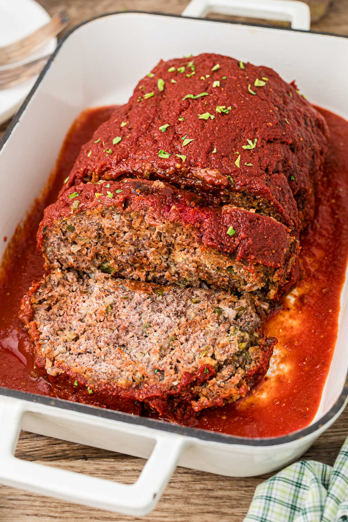 Side view of a sliced Cajun meatloaf with a tomato sauce.