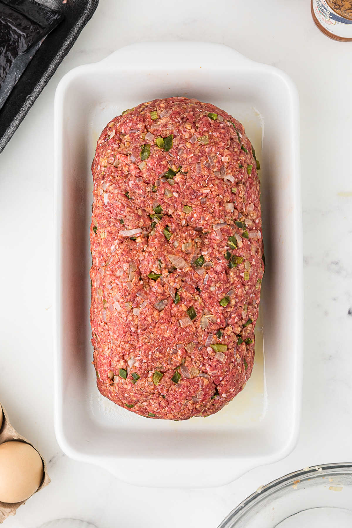 A large meatloaf about to be baked in the oven.