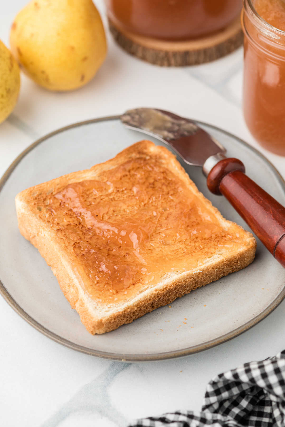 A piece of toast with some Amish Pear Honey spread on top.