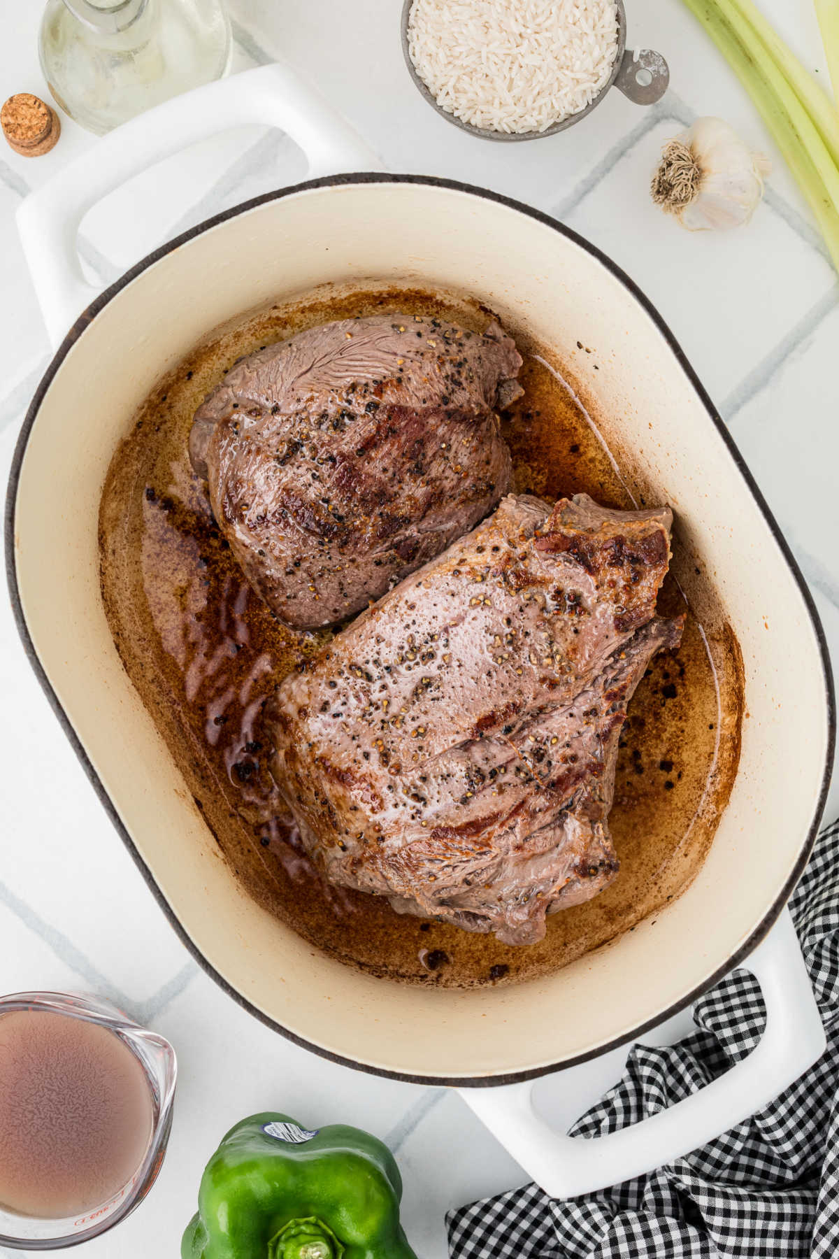 Two roasts being seared in a Dutch oven.