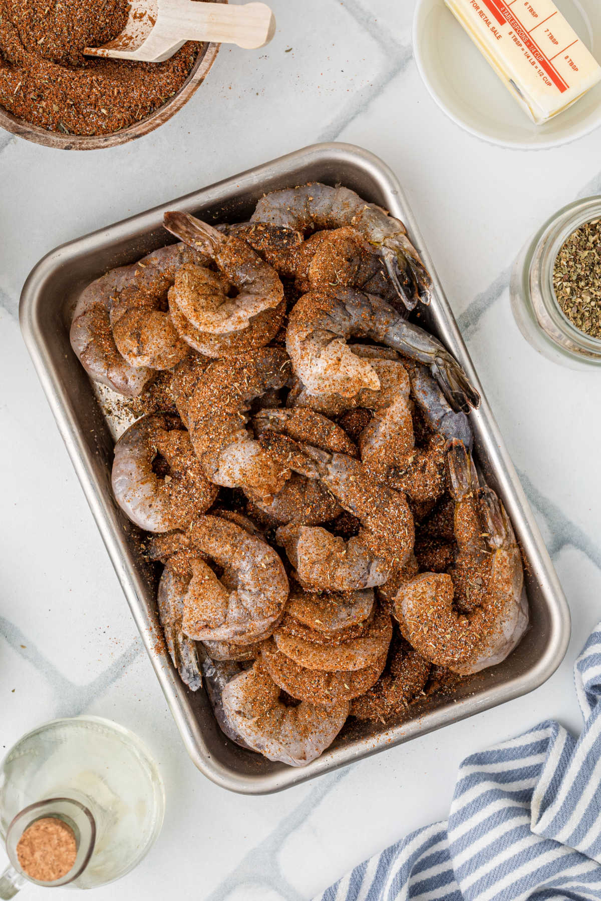 Peeled shrimp covered in blackening seasoning.