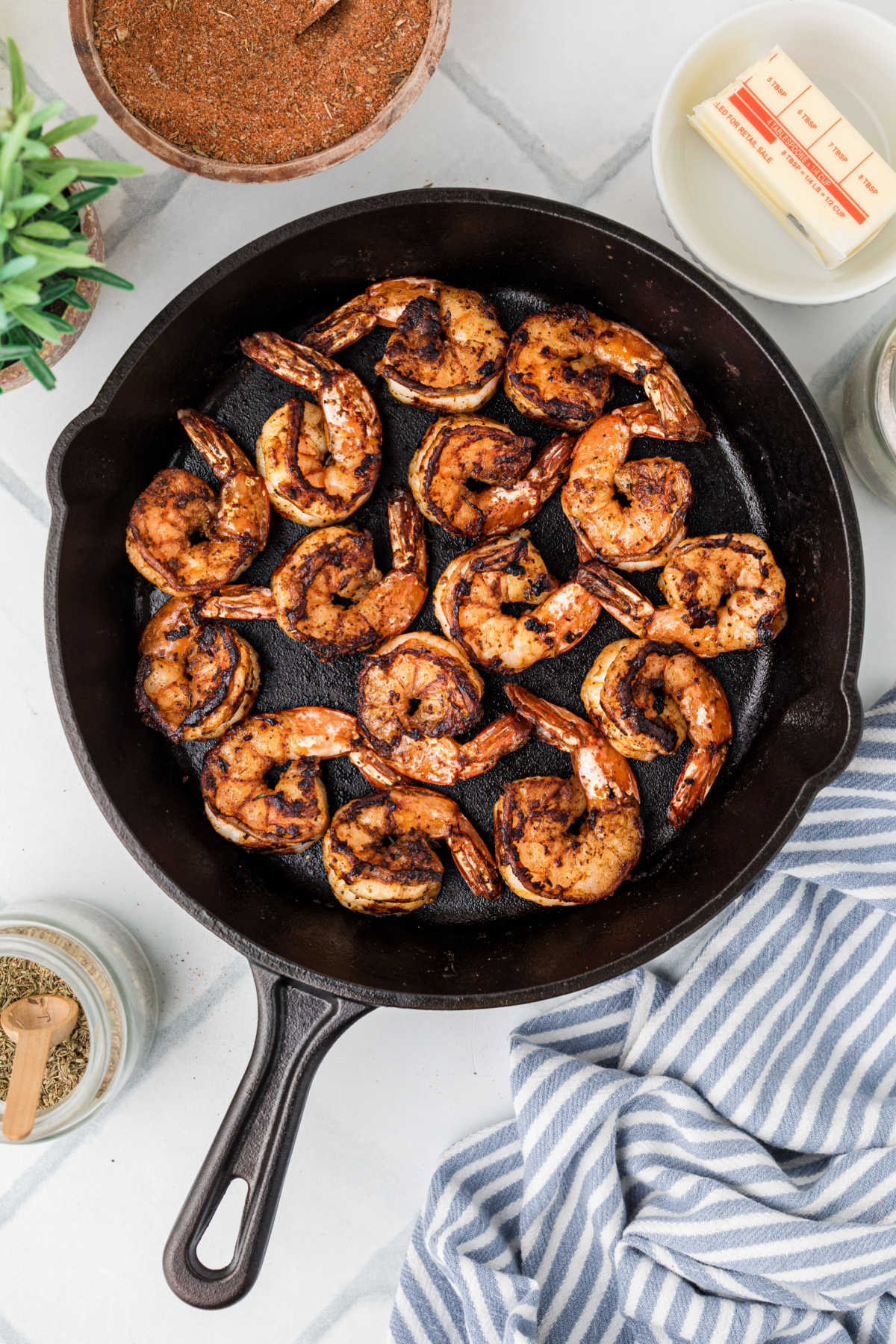 A hot cast iron skillet searing some nicely blackened shrimp.