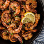 Close up of a cast iron skillet with blackened shrimp.