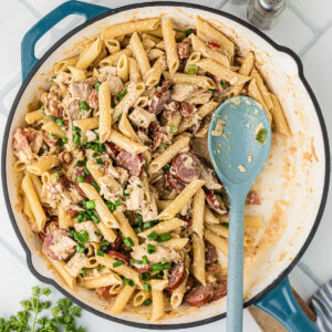 A large skillet filled with Cajun Chicken and Sausage pasta.