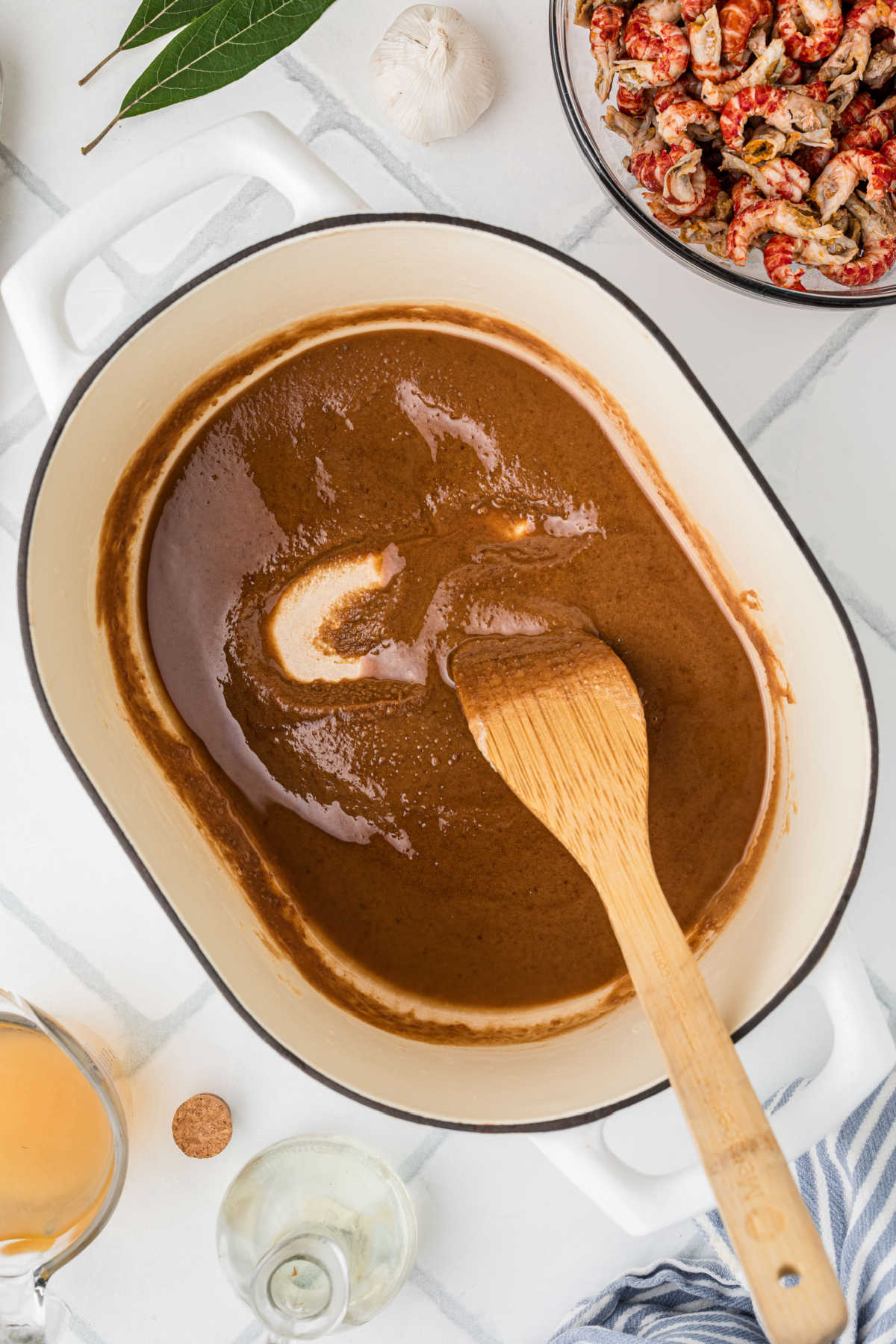 A dark roux, with a wooden spoon stirring it.