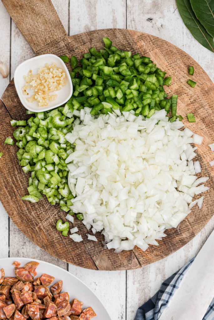 Chopped onions, celery and green bell pepper forming the Cajun holy trinity. There's some garlic in a little bowl, we call that the Pope.