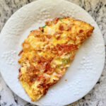 A delicious looking crawfish omelette on a white plate.