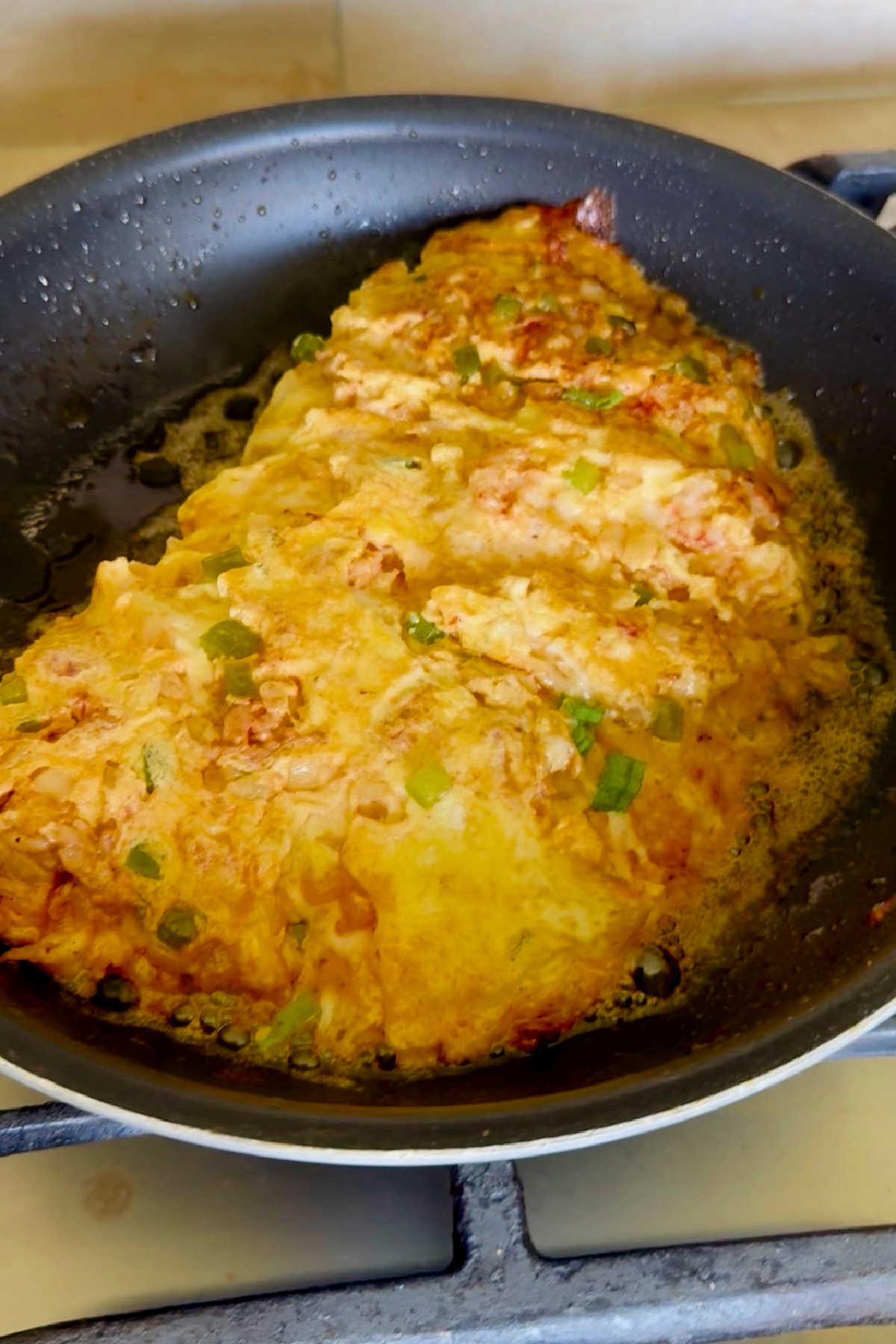 A crawfish omelette in a skillet.