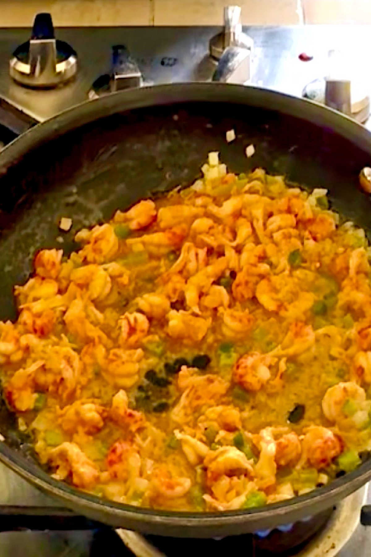 Crawfish tails added to a skillet with butter and onions.