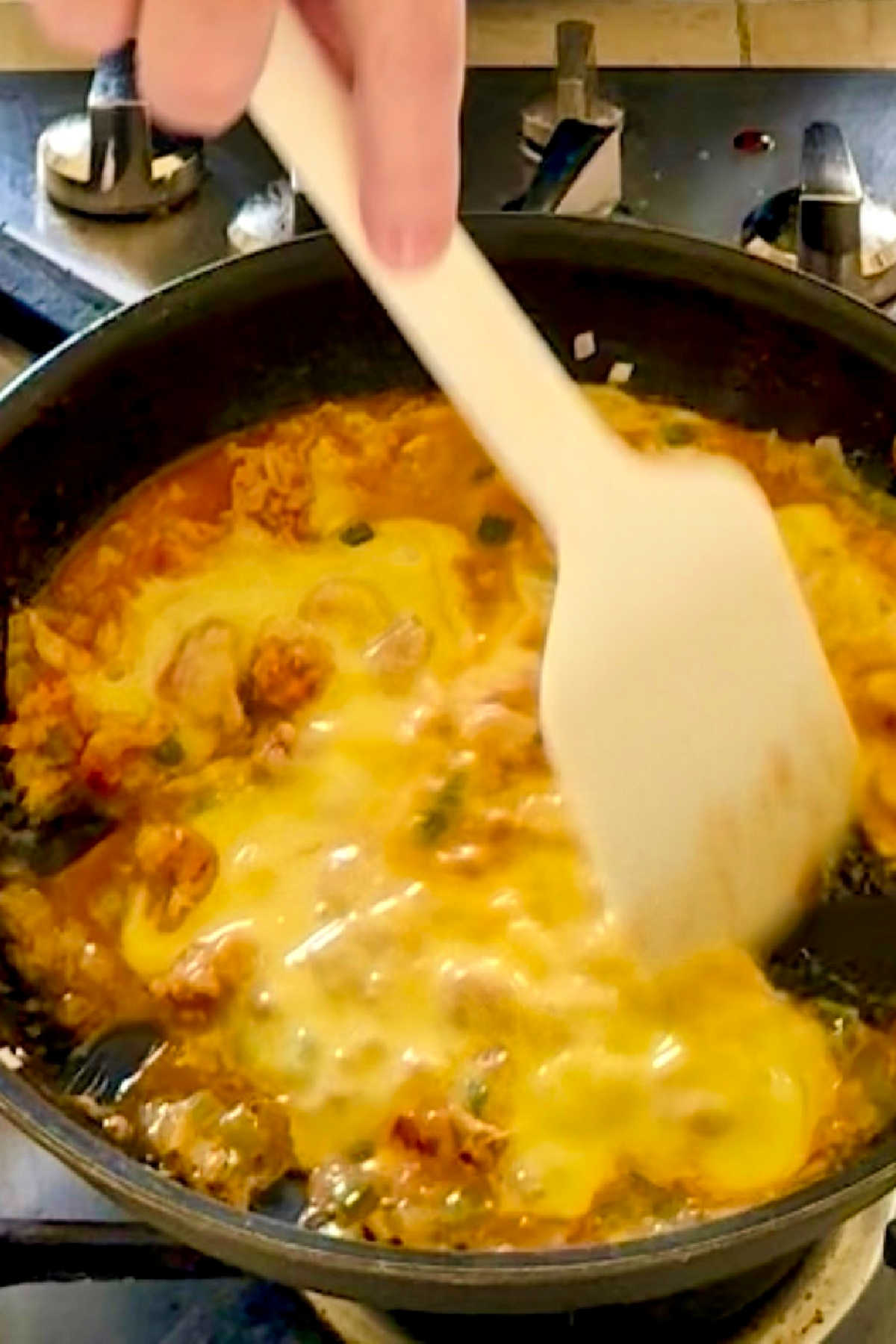Stirring eggs into crawfish tails, in a skillet.