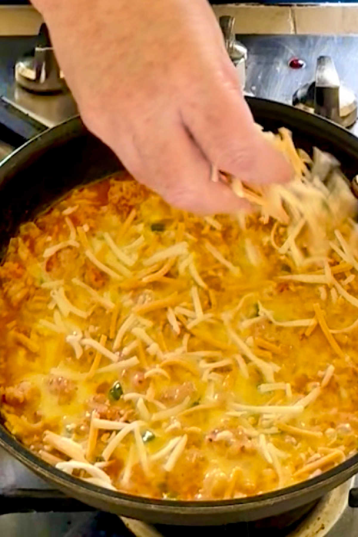 Sprinkling cheese over an omelette.