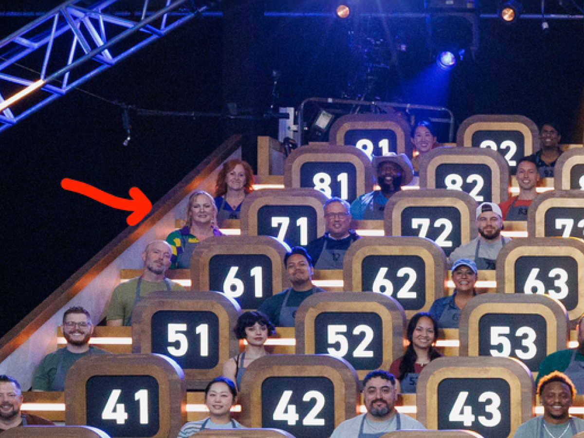 Melanie Cagle sitting in seat 71 on Food Network show 100 Cooks. There's a red arrow pointed to her.